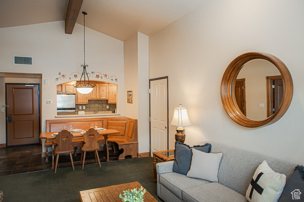 Living room with high vaulted ceiling, visible vents, dark colored carpet, and beam ceiling