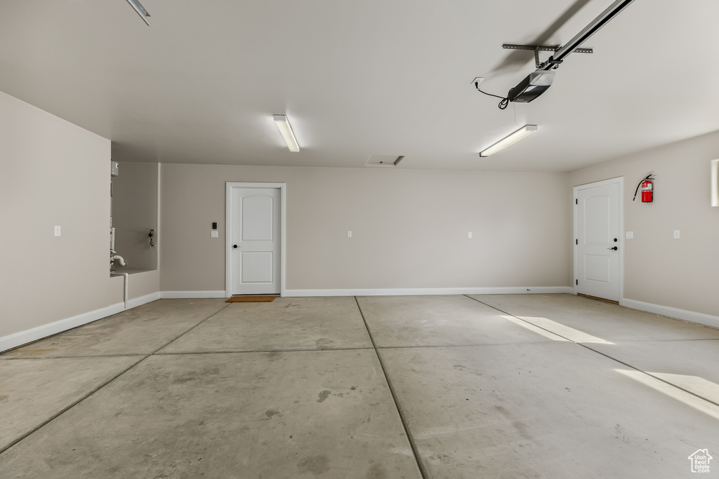 Garage with a garage door opener and baseboards