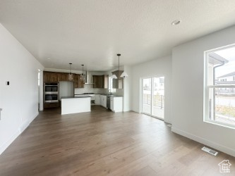 Unfurnished living room featuring wood finished floors and baseboards