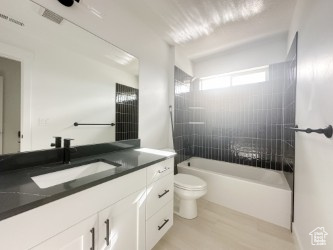 Full bath featuring toilet, vanity, tub / shower combination, and wood finished floors