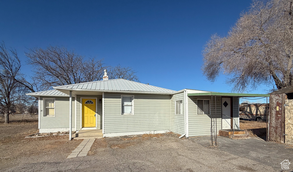 View of front of house with a chimney and metal roof