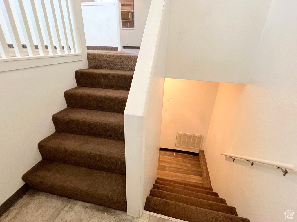Stairs featuring visible vents, baseboards, and wood finished floors