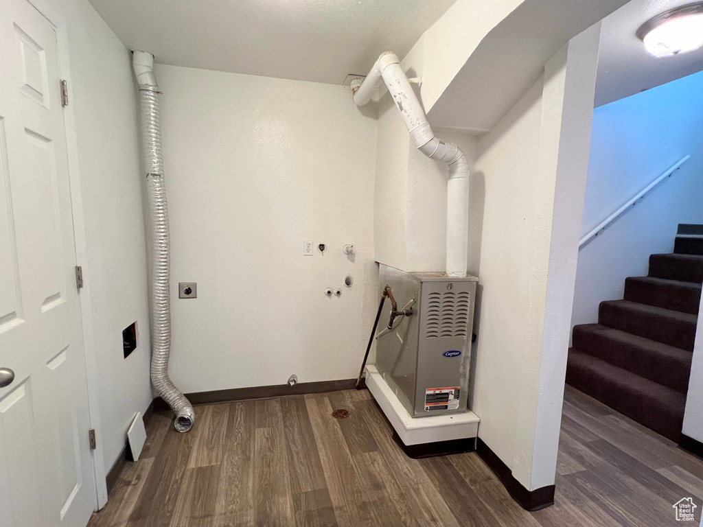 Clothes washing area featuring laundry area, baseboards, dark wood-style flooring, hookup for an electric dryer, and washer hookup