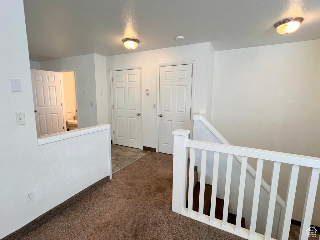 Corridor with an upstairs landing, carpet flooring, and baseboards