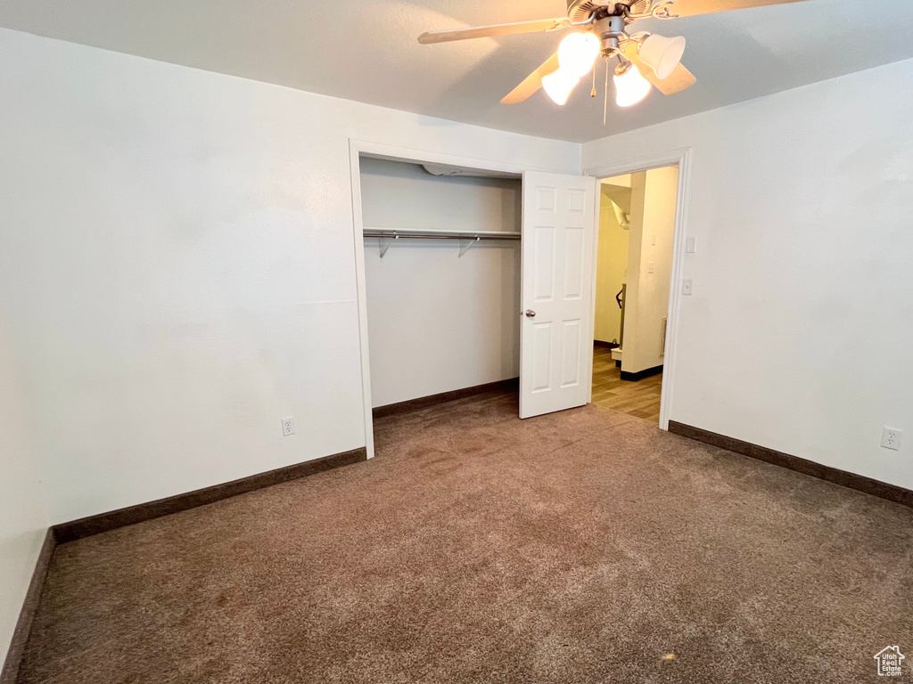 Unfurnished bedroom with a closet, carpet flooring, a ceiling fan, and baseboards