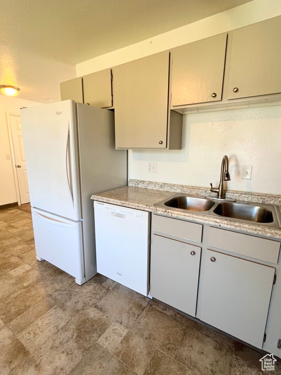 Kitchen with white appliances, light countertops, a sink, and a textured ceiling