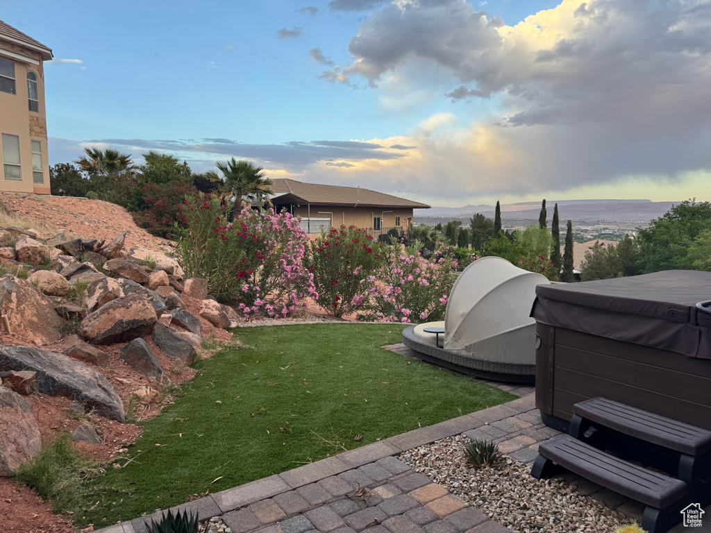 View of green lawn with a hot tub