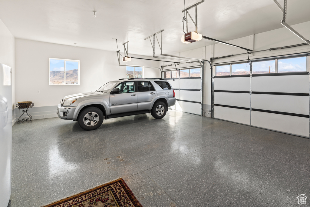Garage featuring baseboards and a garage door opener