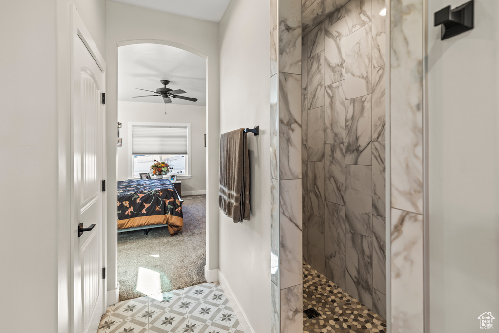 Full bathroom with ceiling fan, ensuite bathroom, baseboards, tile patterned floors, and walk in shower
