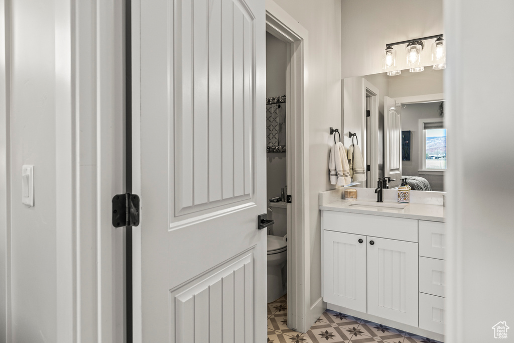 Bathroom featuring toilet, ensuite bath, vanity, and tile patterned floors