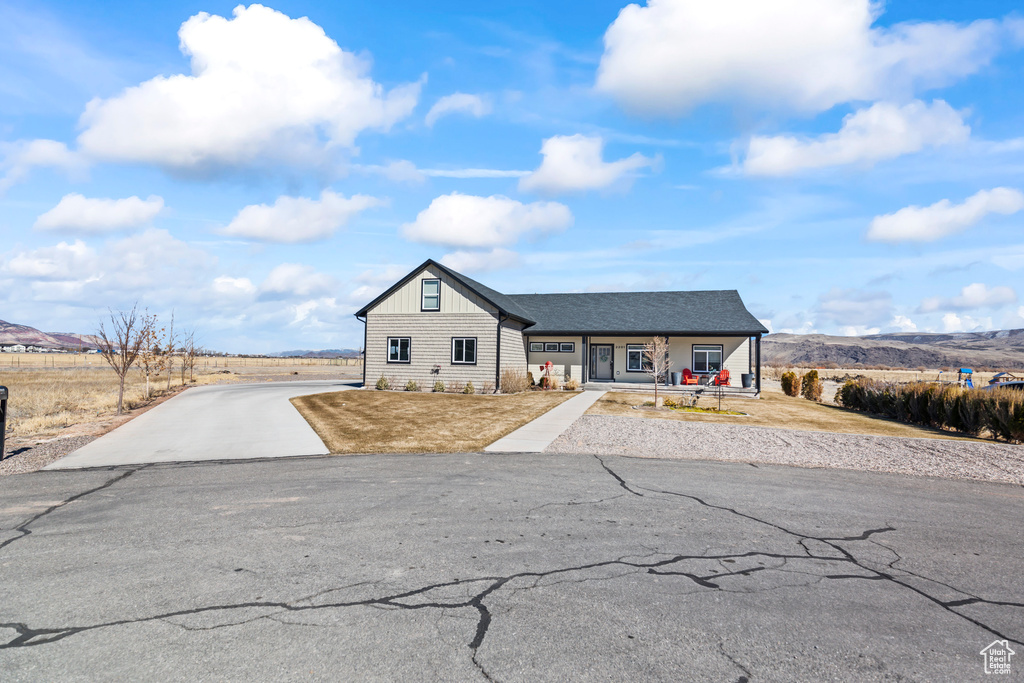 View of front of house featuring driveway, a porch, and board and batten siding