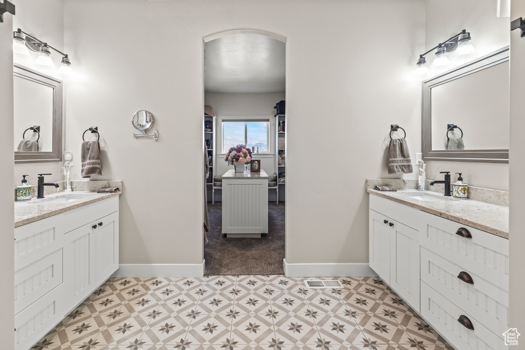 Full bath featuring two vanities, a sink, and tile patterned floors