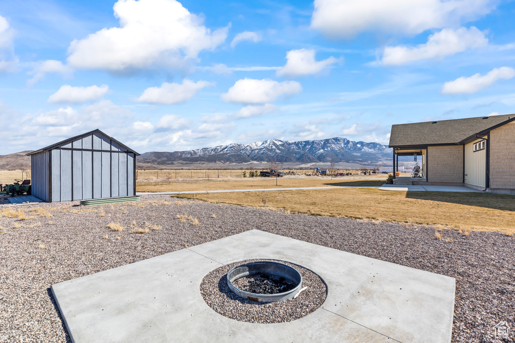 View of yard with a storage shed, an outdoor structure, a patio area, and a mountain view