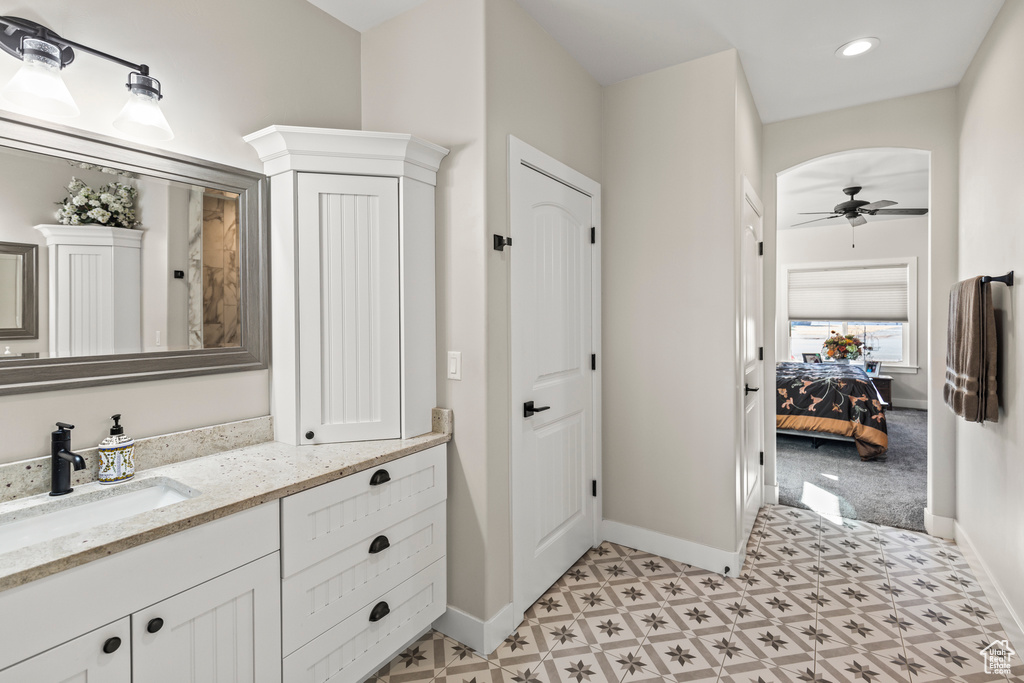 Ensuite bathroom with ceiling fan, recessed lighting, vanity, and baseboards