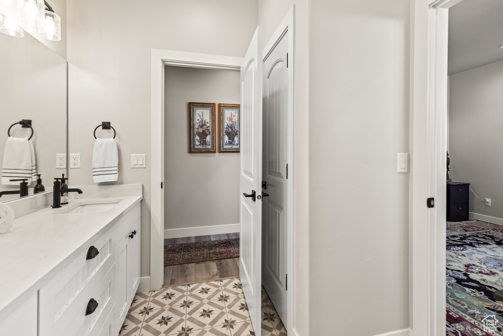 Bathroom featuring tile patterned floors, baseboards, and vanity