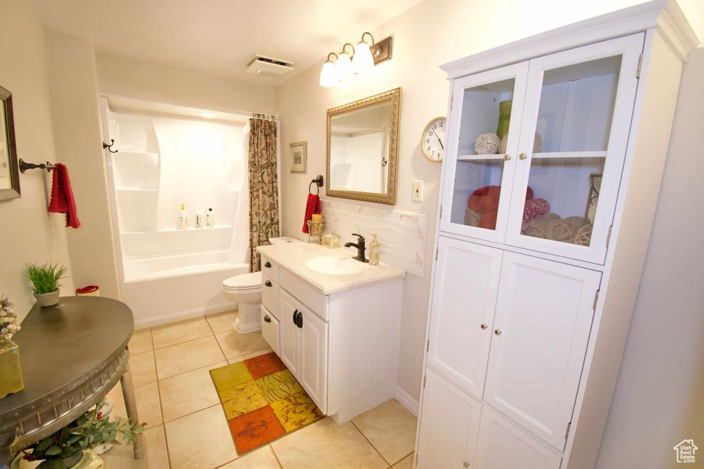 Bathroom featuring tile patterned flooring, toilet, vanity, visible vents, and shower / bath combination with curtain