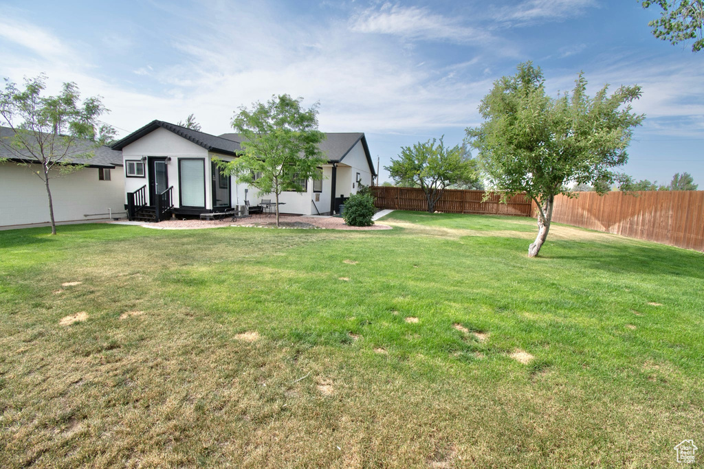 View of yard with entry steps and a fenced backyard