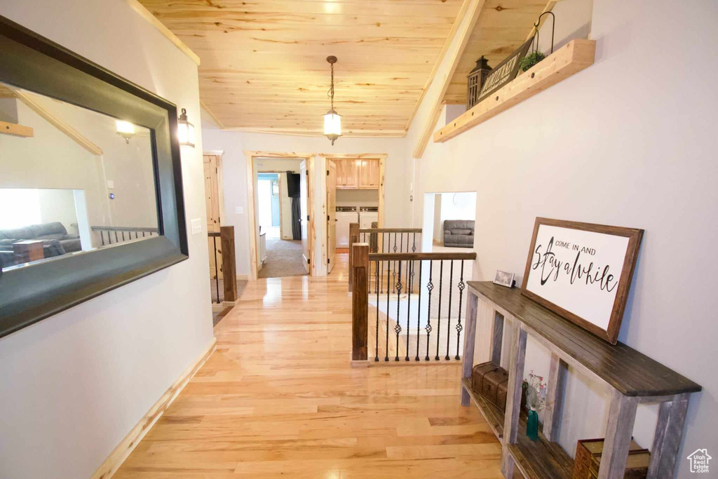 Hall with wood ceiling, baseboards, light wood-style flooring, and an upstairs landing