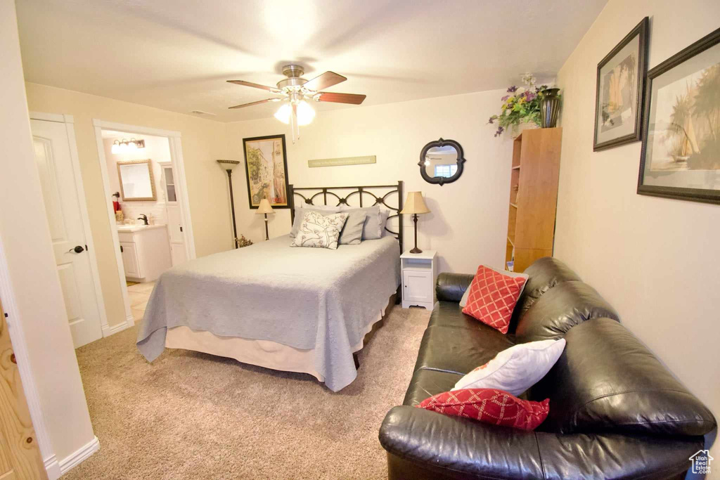 Bedroom featuring carpet floors, a sink, ensuite bath, and ceiling fan