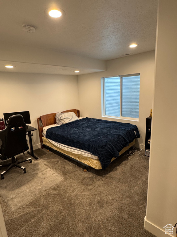 Bedroom with a textured ceiling, dark colored carpet, baseboards, and recessed lighting
