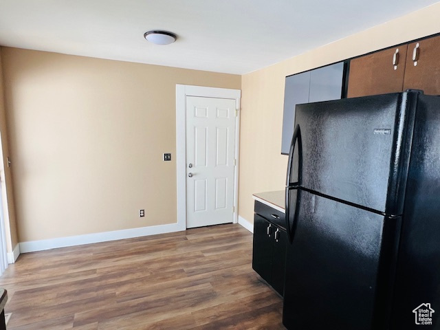 Kitchen featuring light countertops, wood finished floors, freestanding refrigerator, and baseboards