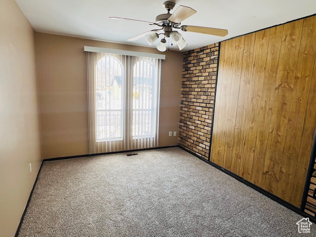 Unfurnished room with visible vents, a ceiling fan, and carpet flooring