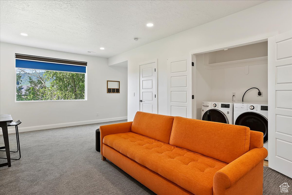 Living area featuring carpet, baseboards, recessed lighting, a textured ceiling, and washer and clothes dryer