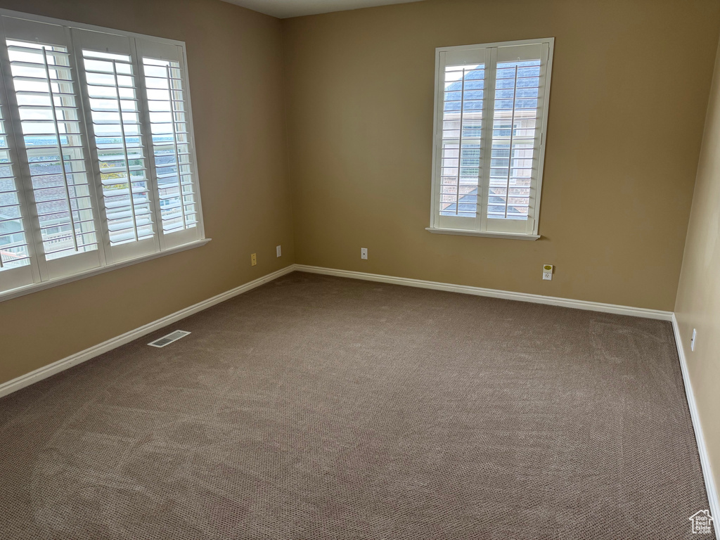 Carpeted empty room with baseboards