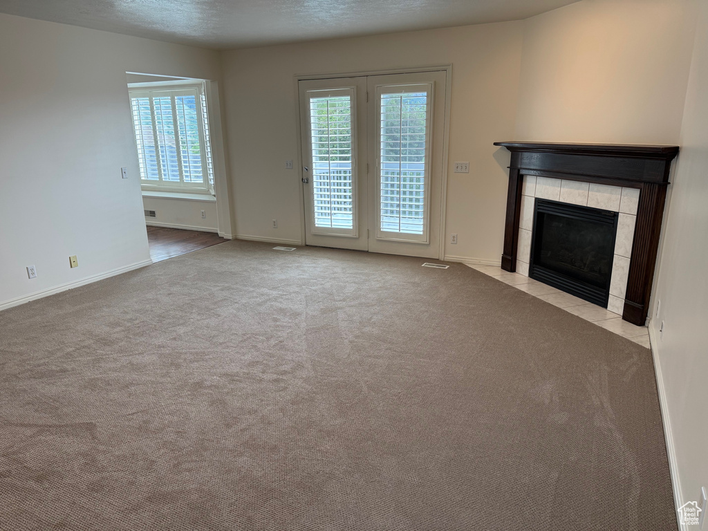 Unfurnished living room with a fireplace, carpet flooring, and baseboards