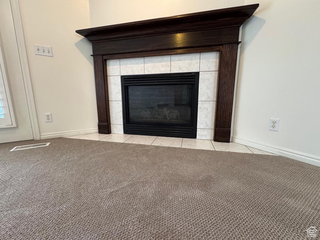Detailed view of a fireplace, baseboards, and carpet flooring