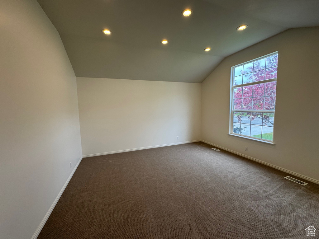 Bonus room featuring vaulted ceiling, baseboards, dark carpet, and recessed lighting