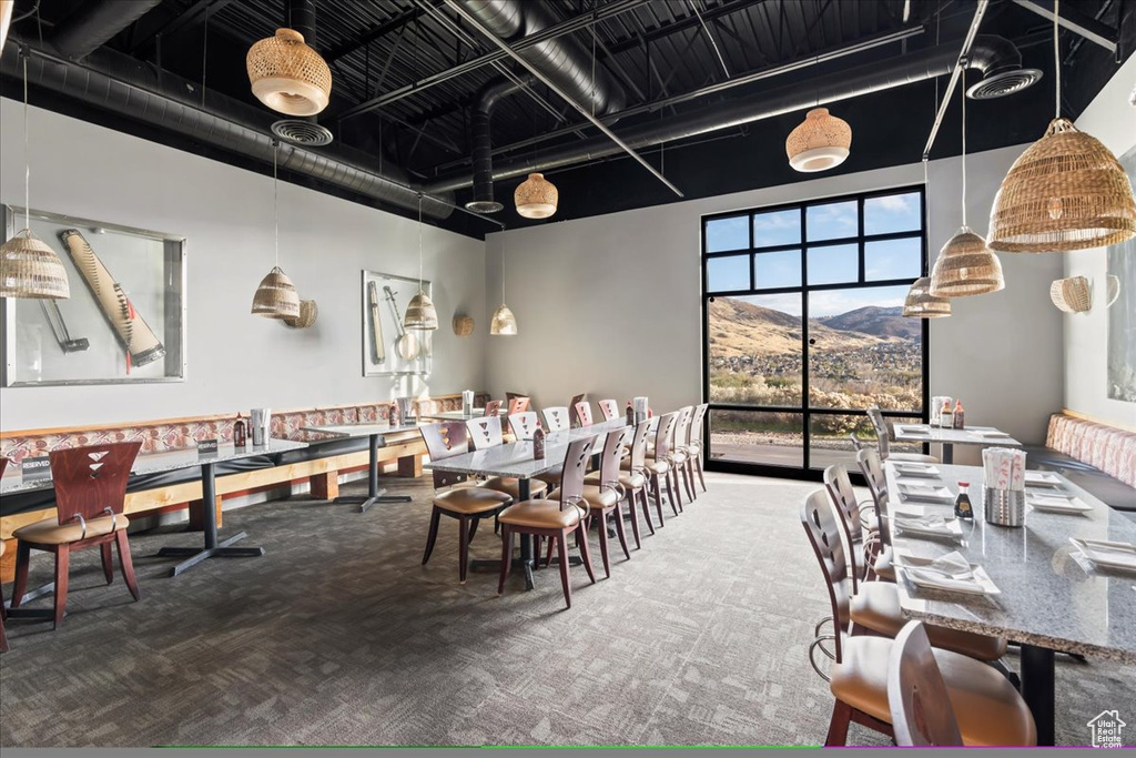 Dining room with carpet, a high ceiling, and a mountain view