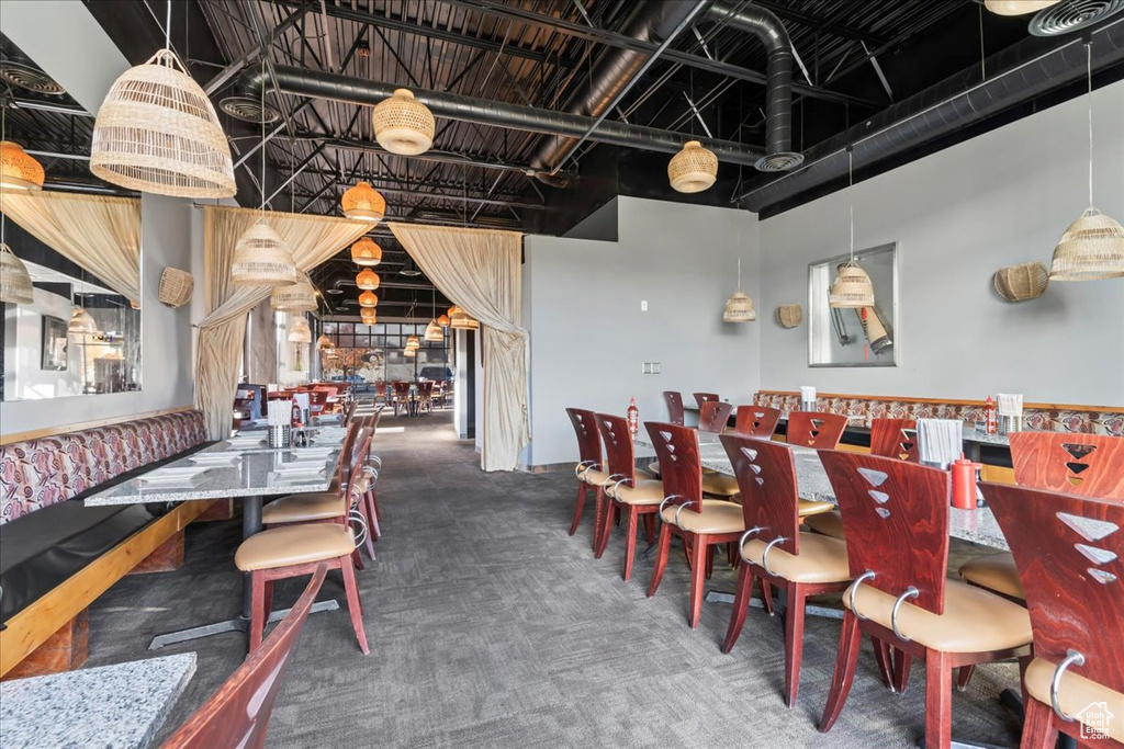 Dining room featuring a towering ceiling and dark carpet