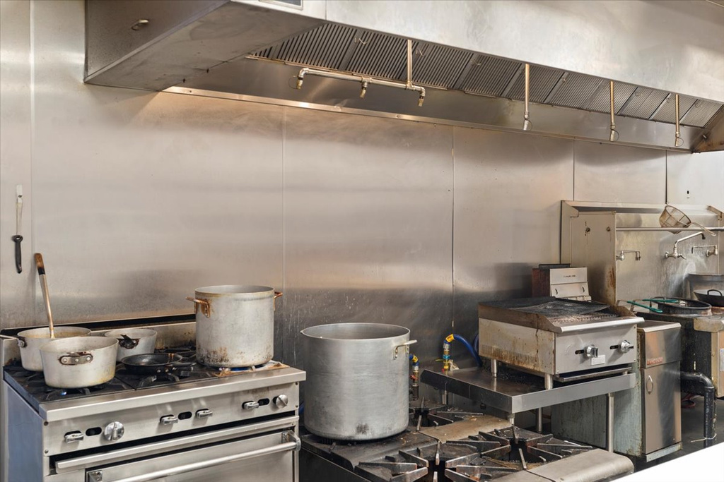 Kitchen featuring wall chimney exhaust hood and high end range