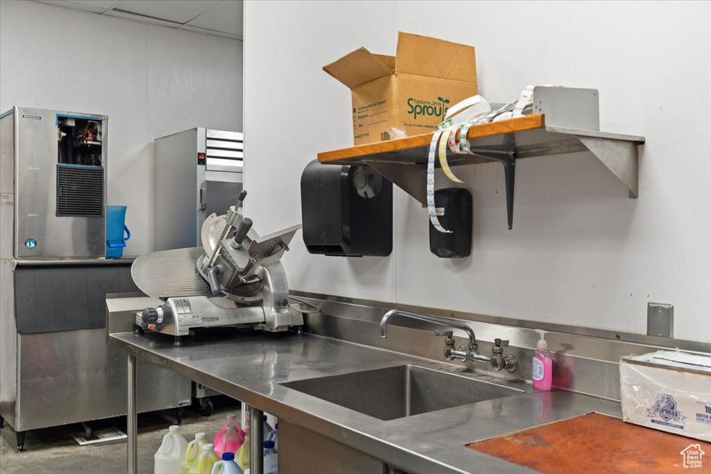 Kitchen with stainless steel countertops, a sink, and a paneled ceiling