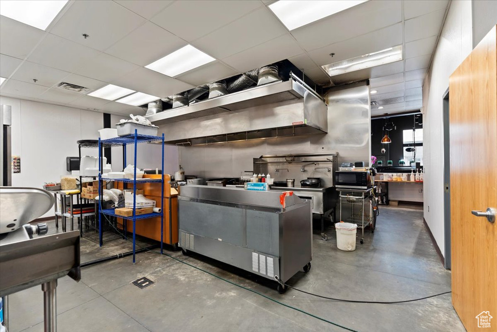 Kitchen featuring finished concrete flooring, visible vents, and a drop ceiling