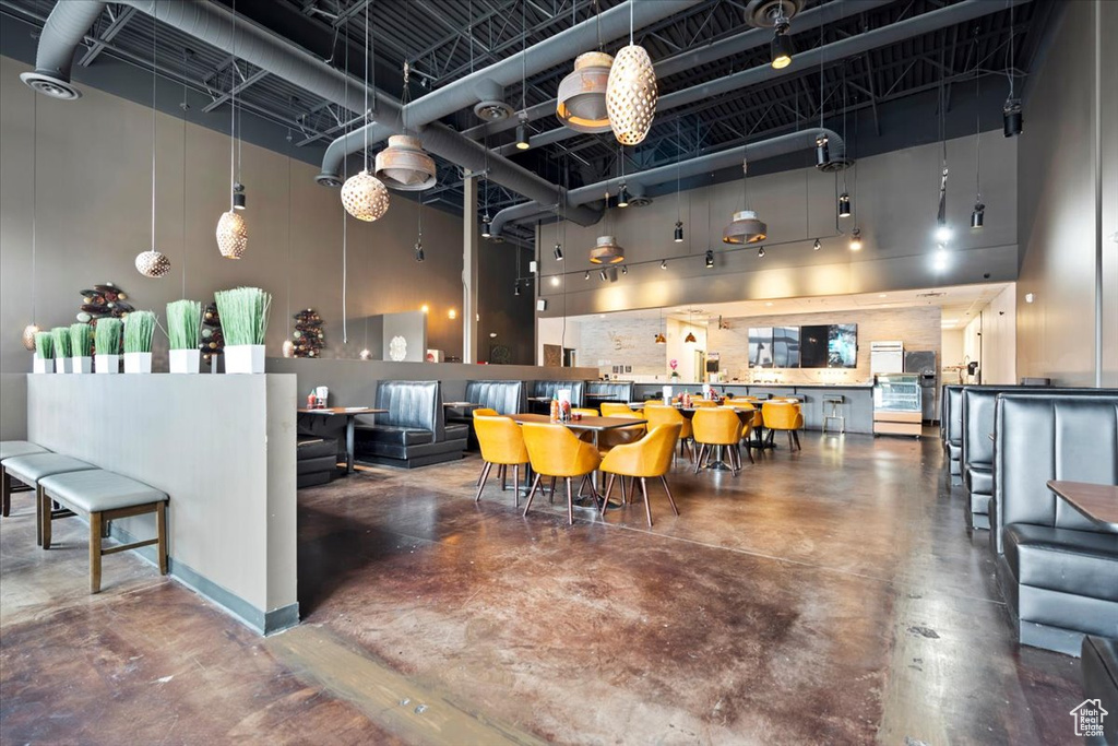 Dining room with a high ceiling and concrete floors