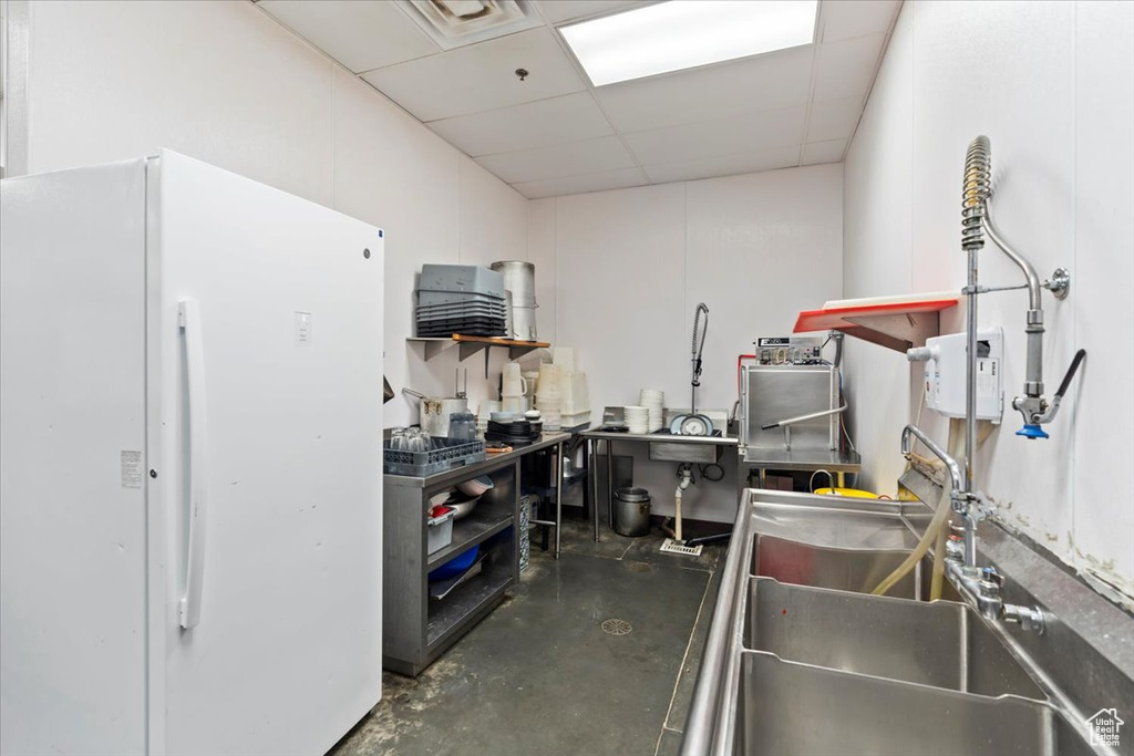 Miscellaneous room with a sink, visible vents, concrete flooring, and a drop ceiling