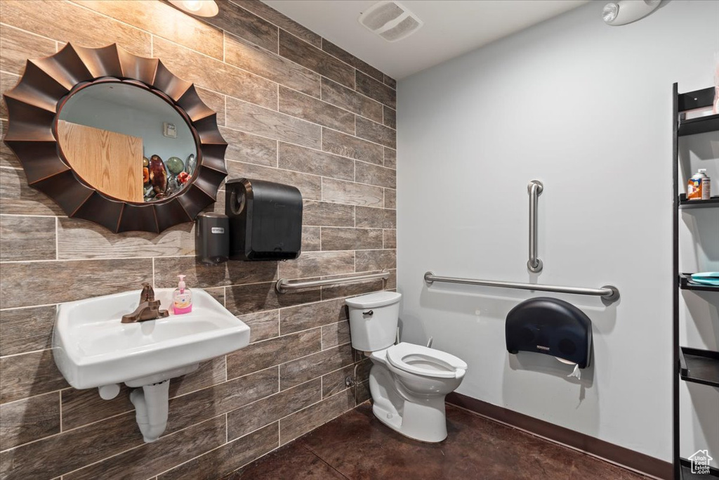 Half bath with tile patterned flooring, visible vents, tile walls, and toilet