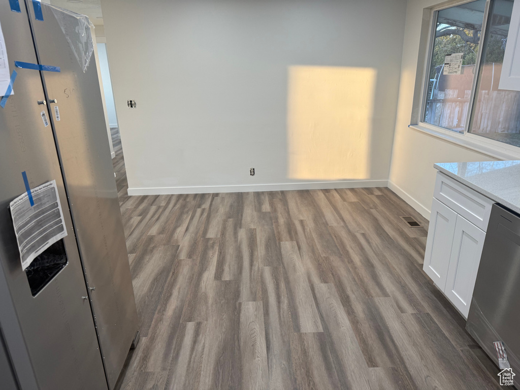 Interior space featuring visible vents, dark wood finished floors, and baseboards