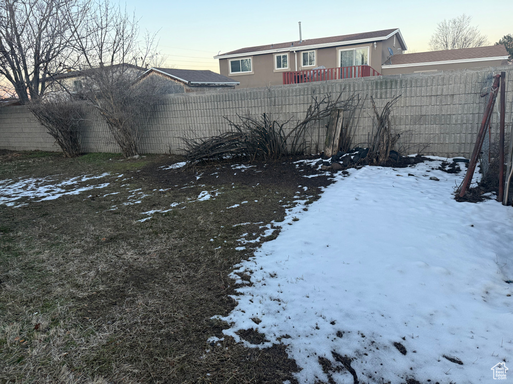 Snowy yard featuring a fenced backyard