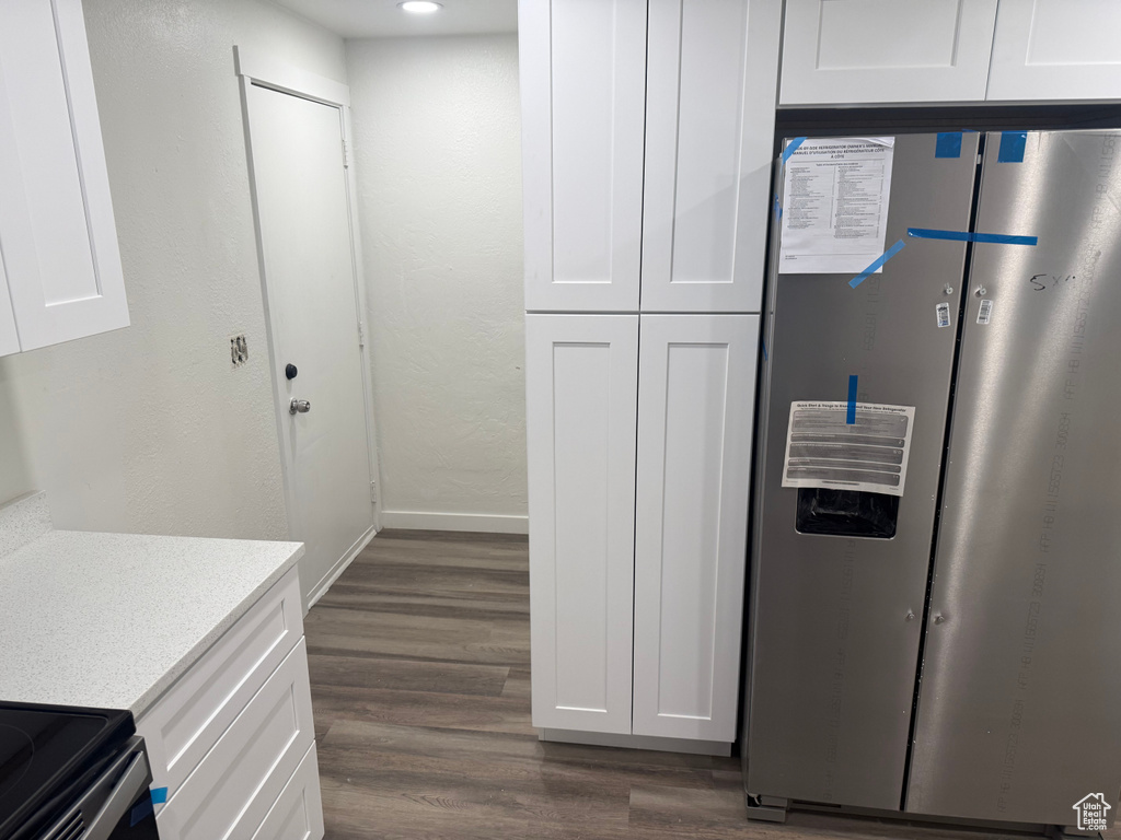 Kitchen with light countertops, dark wood-style flooring, white cabinetry, and stainless steel fridge with ice dispenser