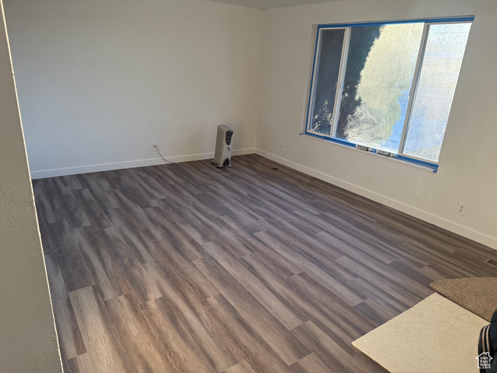 Empty room with dark wood-style floors and baseboards