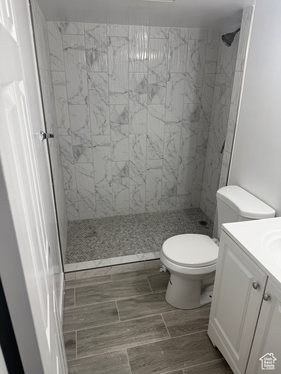 Full bath featuring toilet, a stall shower, and vanity