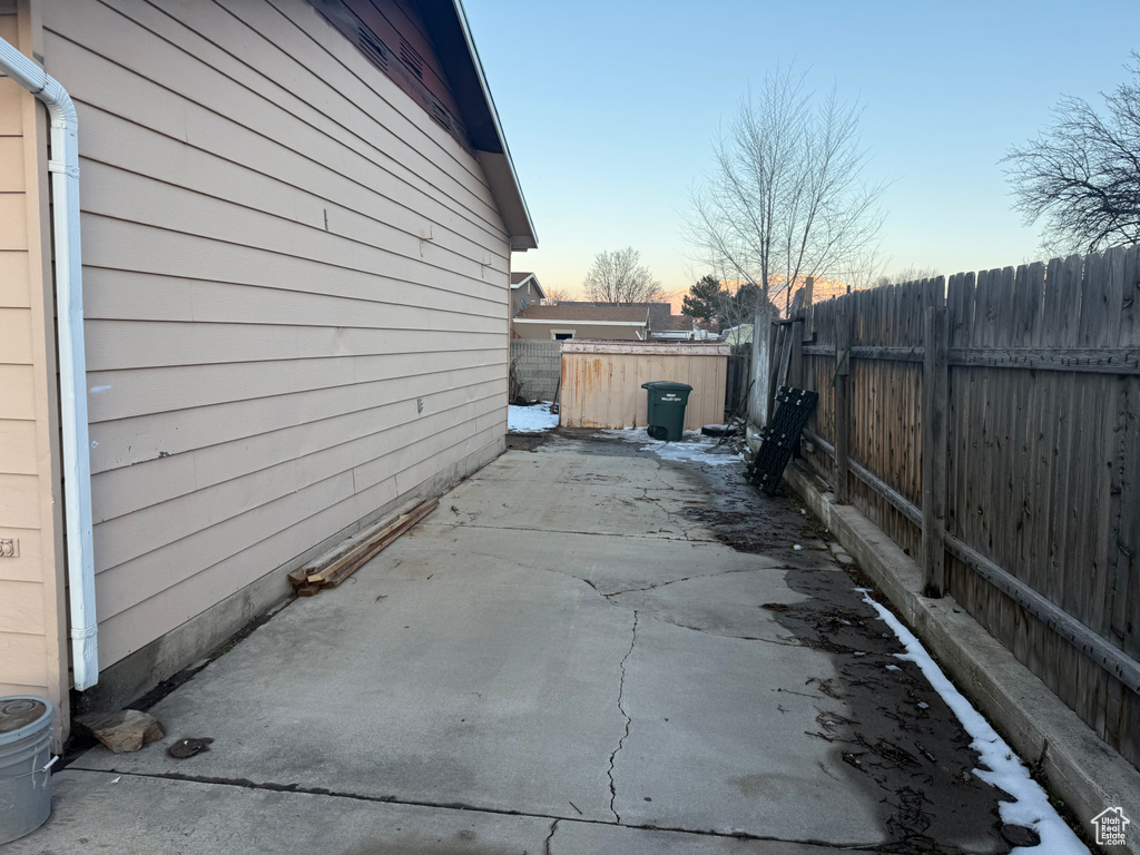 Property exterior at dusk featuring a patio area and a fenced backyard