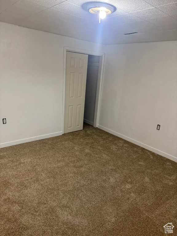 Unfurnished room featuring carpet and baseboards