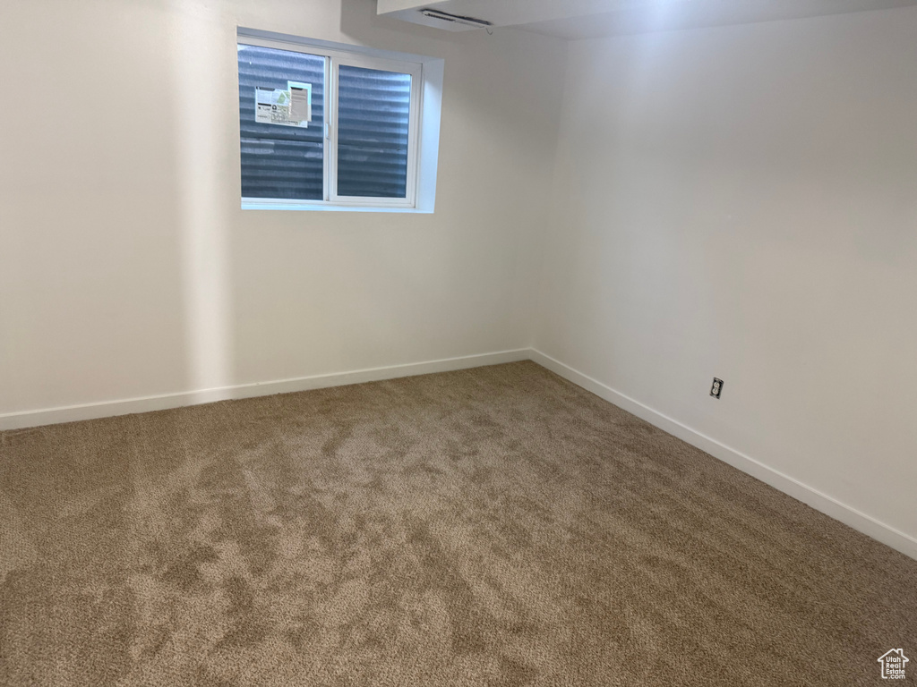 Unfurnished room featuring carpet and baseboards