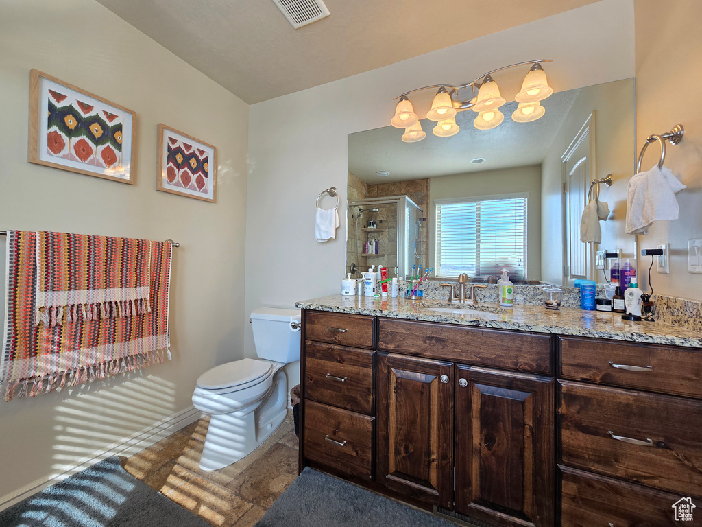 Full bath featuring visible vents, baseboards, toilet, vanity, and a shower stall