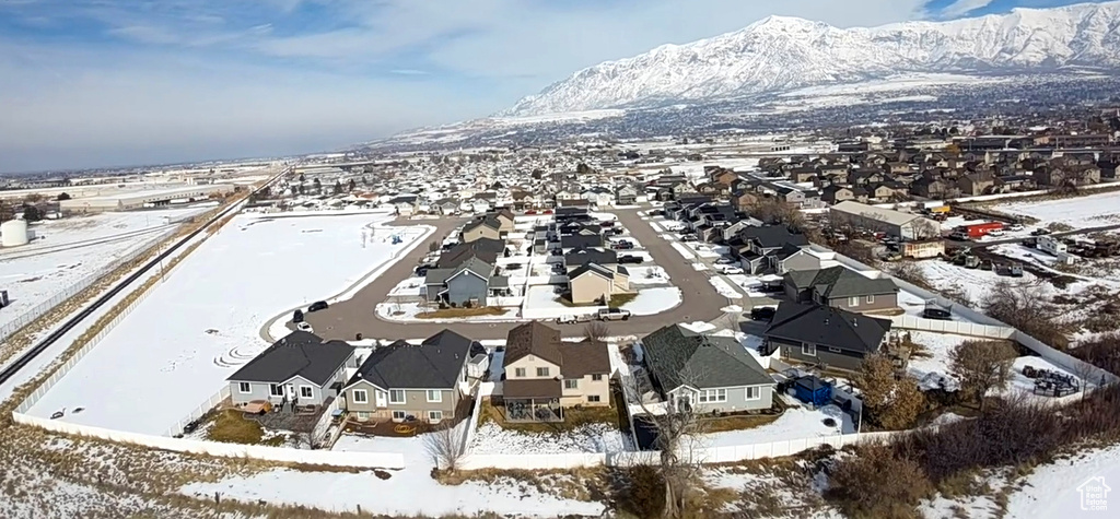 Snowy aerial view featuring a mountain view and a residential view