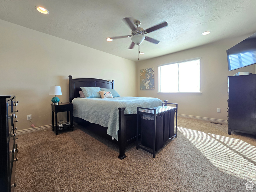 Bedroom featuring dark colored carpet, a textured ceiling, baseboards, and recessed lighting